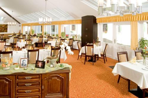a dining room with tables and chairs in a restaurant at Hotel Burg Bollendorf in Bollendorf
