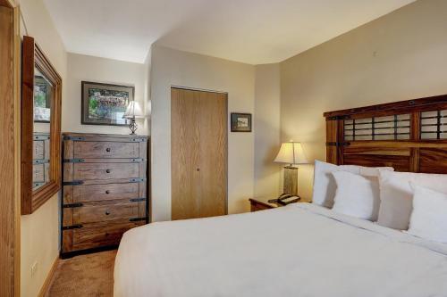 1 dormitorio con 1 cama blanca grande y vestidor en River Mtn Lodge W103, en Breckenridge