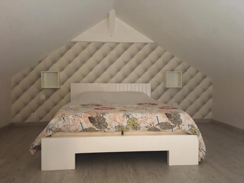 um quarto com uma grande cama branca e uma grande cabeceira de cama. em La maison de Louna em Saint-Parres-lès-Vaudes
