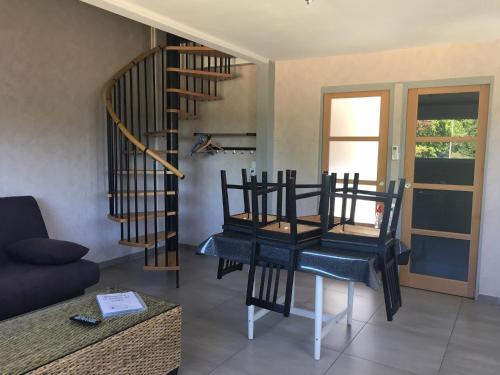 - un salon avec une table et un escalier en colimaçon dans l'établissement La maison de Louna, à Saint-Parres-lès-Vaudes