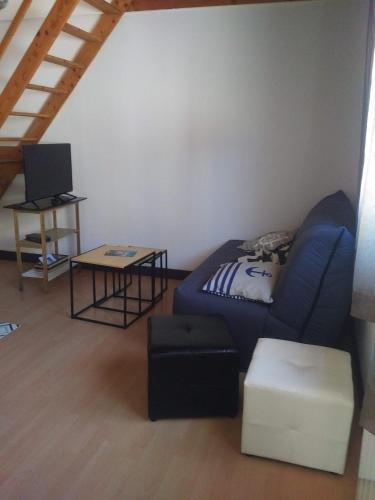 un salon avec un canapé bleu et une table dans l'établissement appartement au coeur de Chatelaillon-plage, à Châtelaillon-Plage