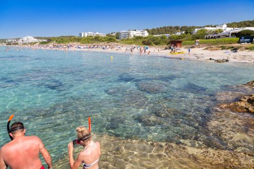two people standing in the water at a beach at Seth Mestral & Llebeig in Santo Tomás