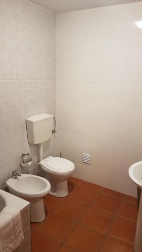 a bathroom with a toilet and a sink at StoneWood Lodge AL in São Vicente Ferreira