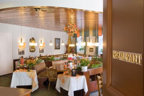 a dining room with tables and chairs and a restaurant at Hotel Burg Bollendorf in Bollendorf
