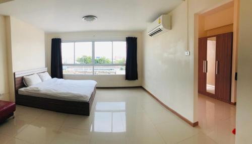 a bedroom with a bed and a large window at My Room in Ratchaburi