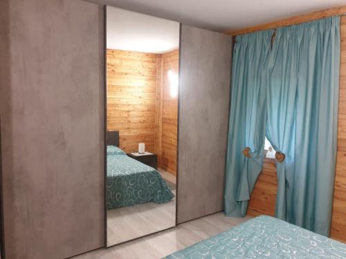 1 dormitorio con 2 camas y espejo en Il Biancone en Champdepraz