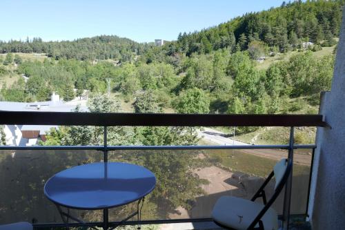 d'une table bleue et de chaises sur un balcon avec une montagne. dans l'établissement La Grande Moucherolle bis, à Villard-de-Lans