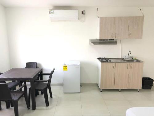 eine Küche mit einem Tisch, einer Spüle und einem Kühlschrank in der Unterkunft CARIBE 102 - 1 in San Andrés