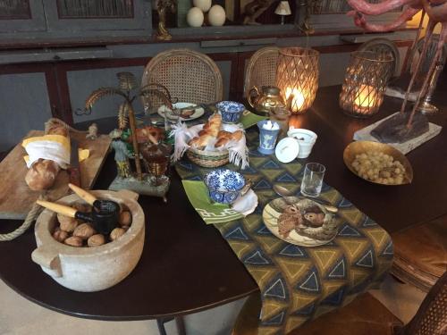 une table avec des assiettes de nourriture dans l'établissement La Maison Rousseau Chambre d'hôtes, à Nîmes