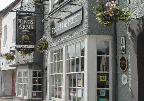 un edificio con puertas y ventanas blancas en una calle en The Kings Arms Hotel, en Malmesbury