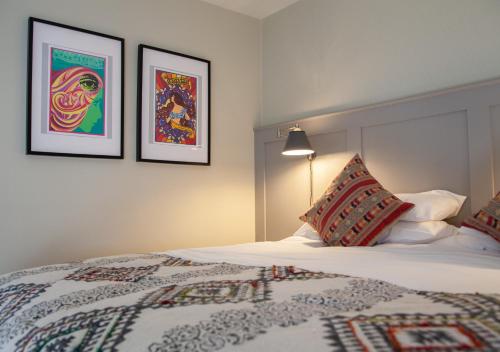 a bedroom with a bed with two pictures on the wall at The Kings Arms Hotel in Malmesbury