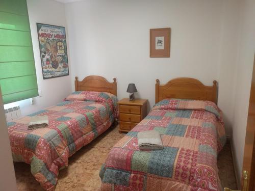 a bedroom with two beds and a night stand at Piso acogedor, junto al Ayuntamiento in Logroño