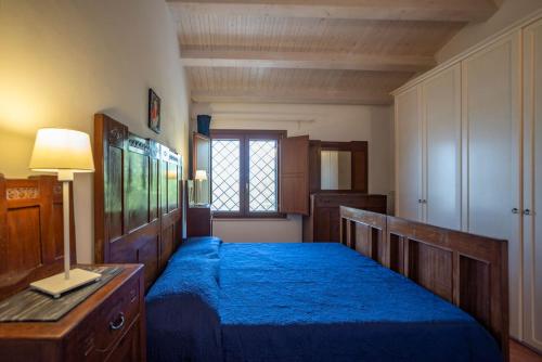 une chambre avec un lit avec des draps bleus et une fenêtre dans l'établissement Country House il Gelso e l'Ulivo appartamento in villa l'Ulivo, à Noto