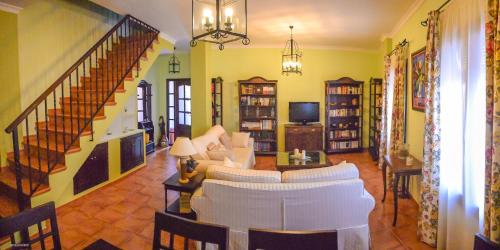 uma sala de estar com mobiliário branco e uma escadaria em CASA BLANCAFLOR em Peñaflor
