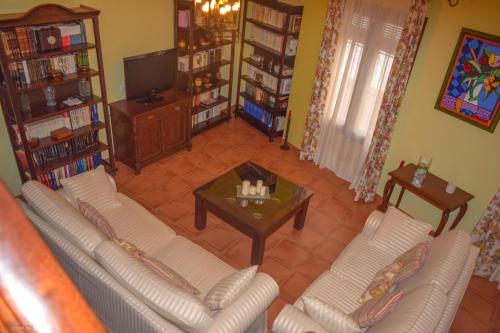 - un salon avec deux canapés blancs et une table basse dans l'établissement CASA BLANCAFLOR, à Peñaflor