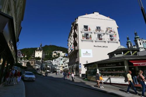 a group of people walking on a city street at Art Deco WOLKER by ASTORIA Hotel & Medical Spa in Karlovy Vary