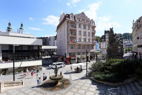 a group of people walking around a city street at Art Deco WOLKER by ASTORIA Hotel & Medical Spa in Karlovy Vary
