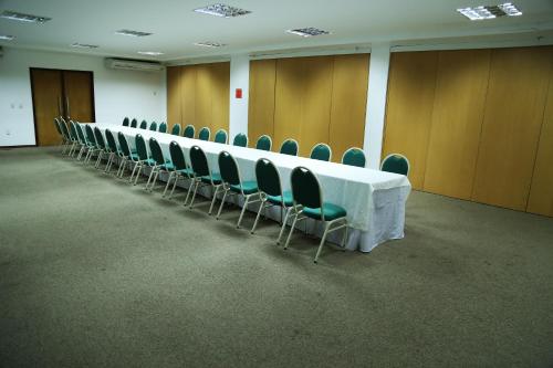 a long table in a room with green chairs at Garbos Trade Hotel in Mossoró