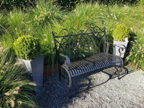 a black bench sitting in front of some plants at Carrera - Ferienhaus mit Traumgarten (120m2) für max. 2 Personen in Valendas