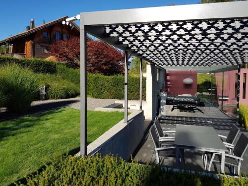 a patio with a table and chairs under a pergola at Carrera - Ferienhaus mit Traumgarten (120m2) für max. 2 Personen in Valendas