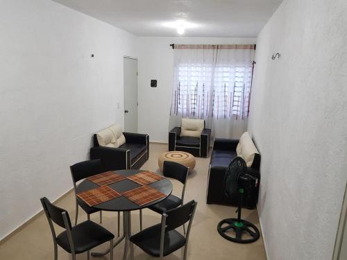 een woonkamer met een tafel en stoelen bij Casa en Mahahual cerca de la playa in Mahahual