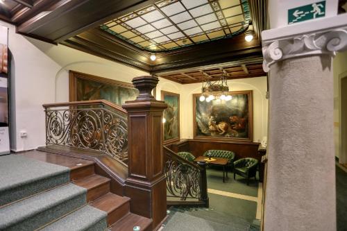 a hallway with a staircase in a building at Art Deco WOLKER by ASTORIA Hotel & Medical Spa in Karlovy Vary