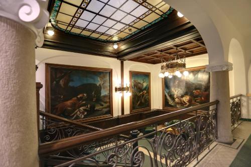a hallway with paintings on the wall in a building at Art Deco WOLKER by ASTORIA Hotel & Medical Spa in Karlovy Vary