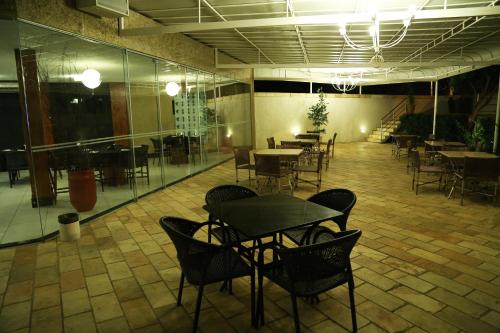 a dining room with tables and chairs in a building at Garbos Trade Hotel in Mossoró