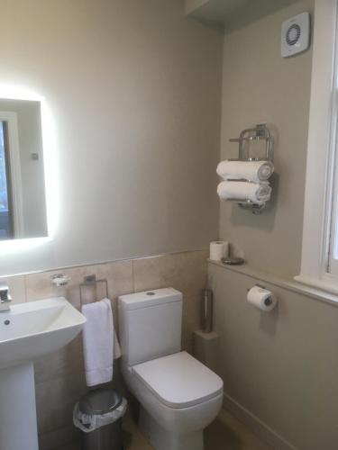 a bathroom with a white toilet and a sink at Elmdon Lodge in Birmingham