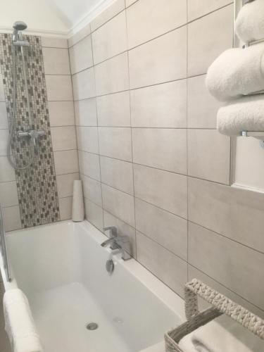 a white bathroom with a tub and a shower at Elmdon Lodge in Birmingham