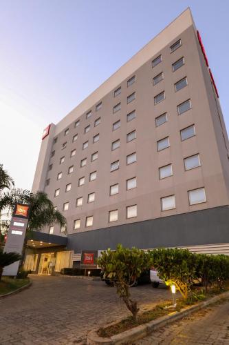 a large building with a tree in front of it at ibis Montes Claros Shopping in Montes Claros
