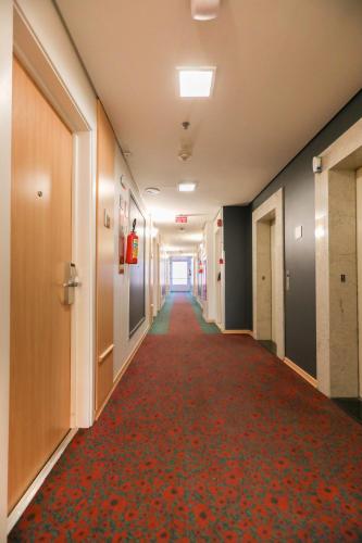 an empty hallway in an office building with a red carpet at ibis Montes Claros Shopping in Montes Claros