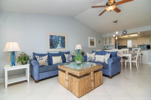 a living room with blue couches and a table at Sandpiper Beach #405 in Sanibel