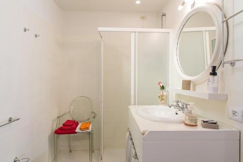 a white bathroom with a sink and a mirror at Flowers' Lane in Milan