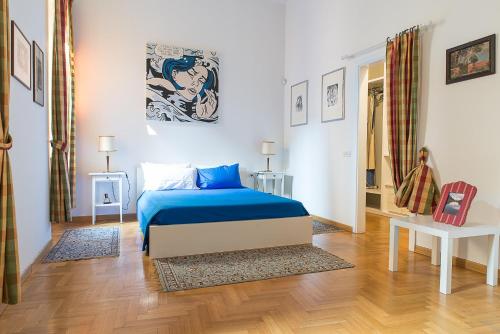 sypialnia z niebieskim łóżkiem w pokoju w obiekcie Flowers' Lane w Mediolanie