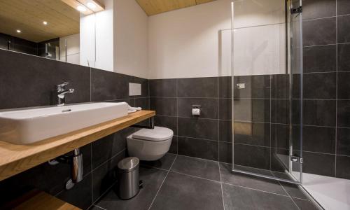 W łazience znajduje się umywalka, toaleta i prysznic. w obiekcie Gadmer Lodge - dein Zuhause in den Bergen w mieście Gadmen