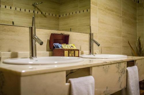 Dos lavabos sobre una encimera en un baño. en Hostal Rural el Nacimiento, en Deifontes
