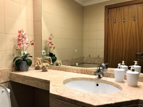 a bathroom with a sink and a large mirror at Funchal Apartment, with pool in Funchal