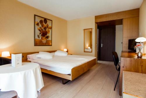 une chambre d'hôtel avec un lit et une table dans l'établissement Hôtel Le National, à Delémont