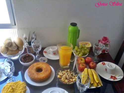 ein Tisch mit Tellern voller Essen und Getränke in der Unterkunft Mamma's Hostel e Pousada in Caxias do Sul