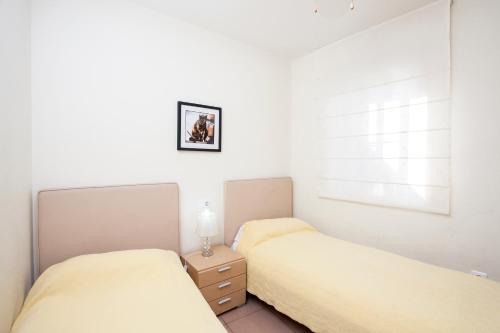 dwa łóżka w sypialni z lampką na stoliku nocnym w obiekcie Playa Burriana Rubasol Nerja w mieście Nerja