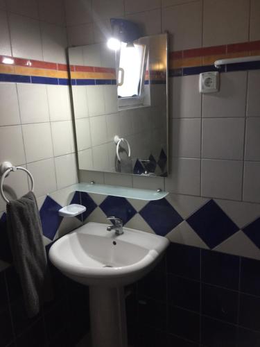 a bathroom with a sink and a mirror at Quinta Forum in Tocha