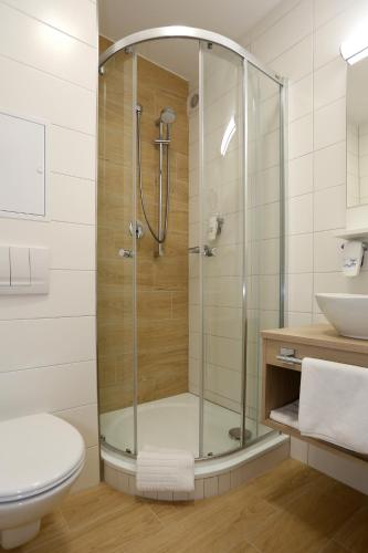 a shower in a bathroom with a toilet and a sink at ASTORIA Hotel & Medical Spa in Karlovy Vary