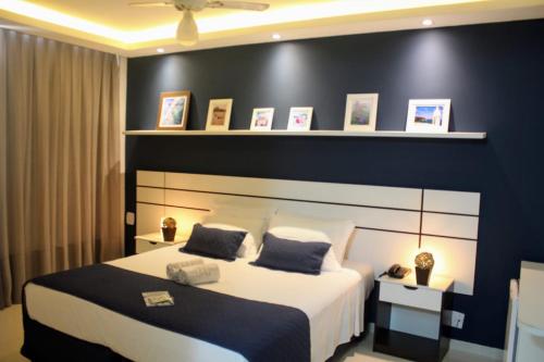 ein Schlafzimmer mit einem großen Bett und einer schwarzen Wand in der Unterkunft Hotel Marlen in Cabo Frio