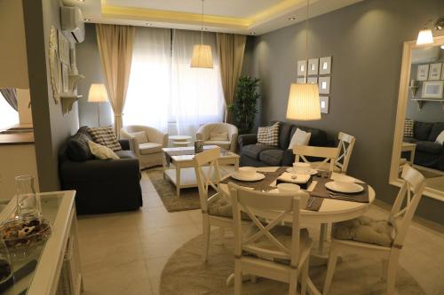 a living room with a table and a dining room at Elite Residency in Amman