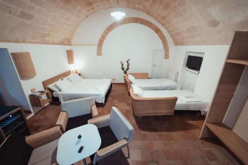 a room with two beds and a table and chairs at Gradelle San Nicola in Matera