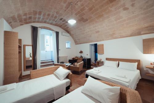 a living room with two beds and a brick wall at Gradelle San Nicola in Matera