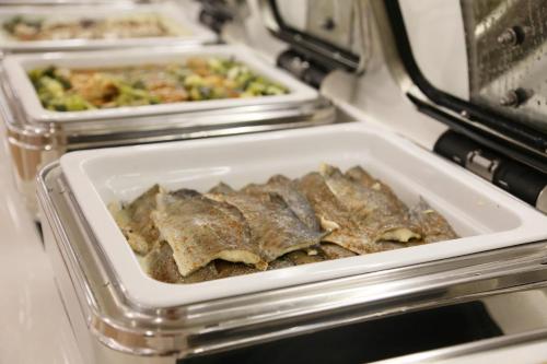 three trays of food are sitting in an oven at ASTORIA Hotel & Medical Spa in Karlovy Vary