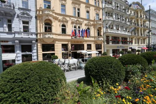 a horse drawn carriage in front of a building at ASTORIA Hotel & Medical Spa in Karlovy Vary