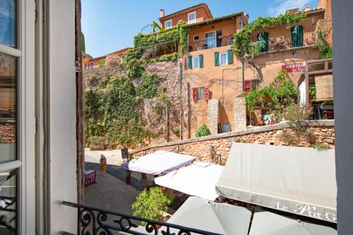 a balcony with a view of a building at Maison d'hôtes Une hirondelle en Provence in Roussillon
